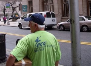 Expedited courier group delivery guy carrying parcel along street