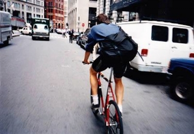 Bike messenger riding bike carrying courier bag